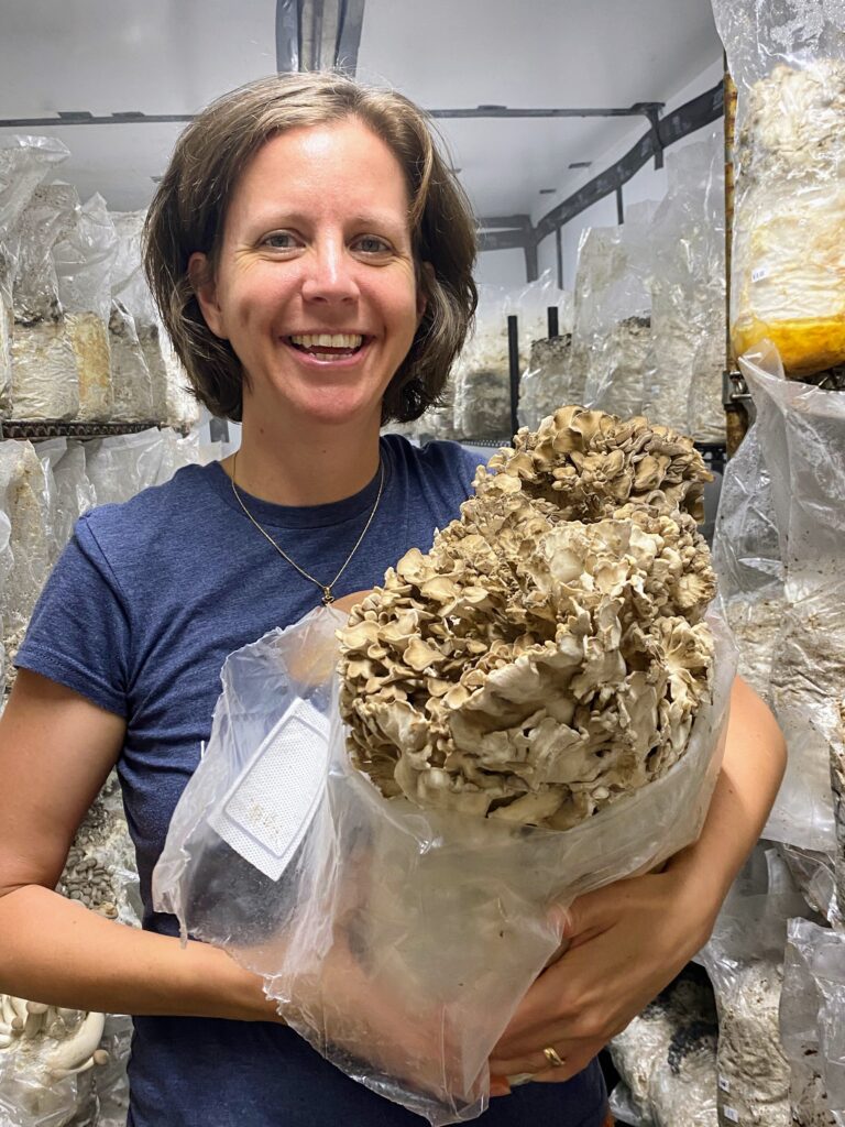 Photo of Fat Moon Farm owner Elizabeth Almeida holding a mushroom block